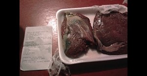 Plato con carne en mal estado, mostrando descomposición y con un recibo al lado.
